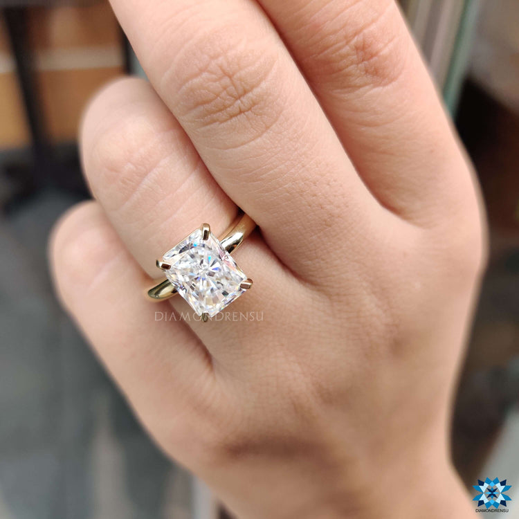 Radiant engagement ring handcrafted in yellow gold with clean design.
