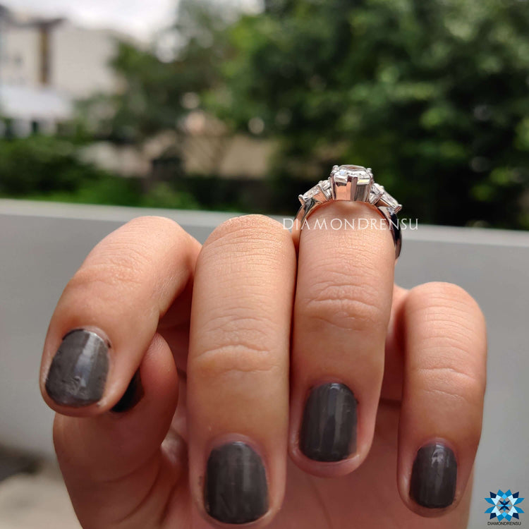 Kite cut side stone ring paired with a bold moissanite centre and prong setting.
