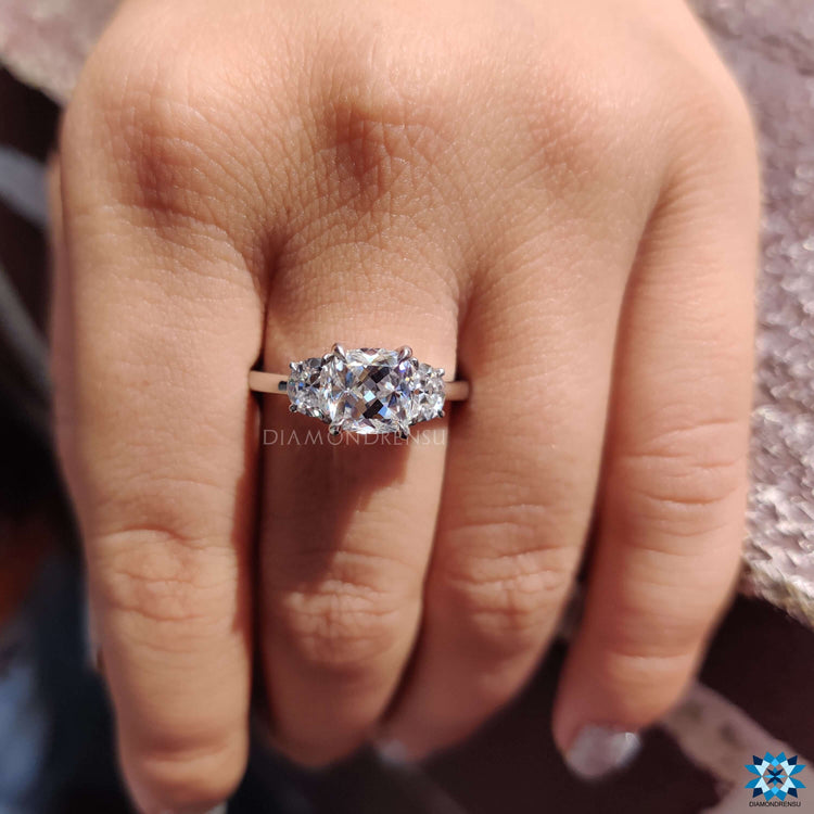 Cushion cut center stone ring with half moon side stones.
