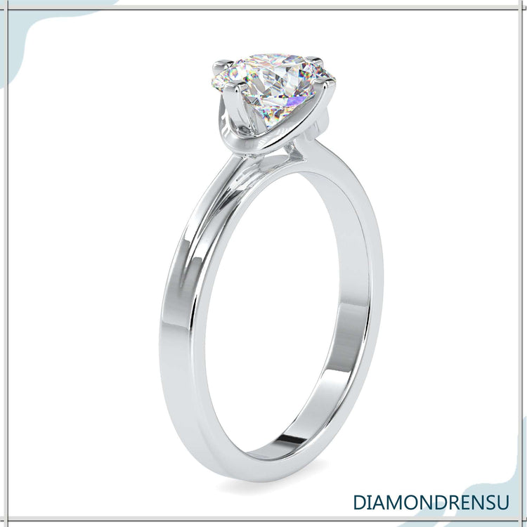 Rose gold engagement ring with round diamond and tab prongs.
