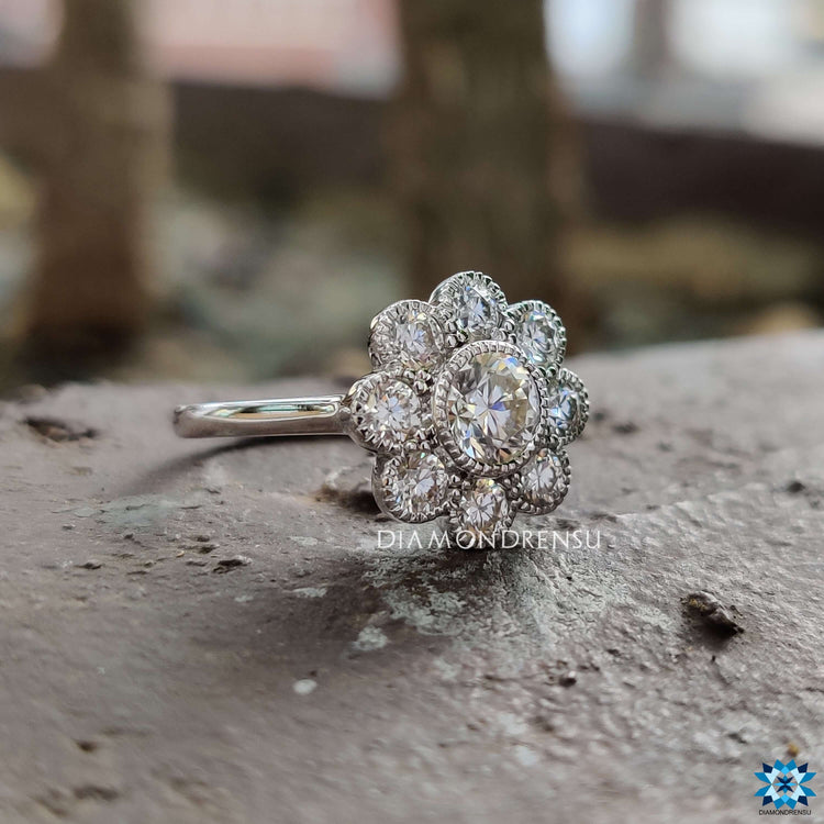Round brilliant cut moissanite ring in a cathedral setting with floral style.
