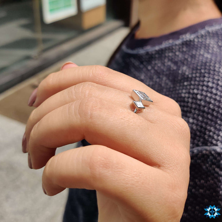 Lozenge cut engagement ring with bezel settings.
