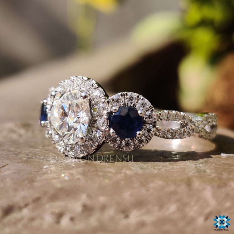 Blue sapphire and moissanite halo ring with elegant twisted design.
