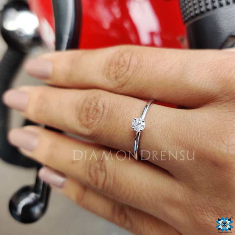 White gold moissanite ring with round center stone.
