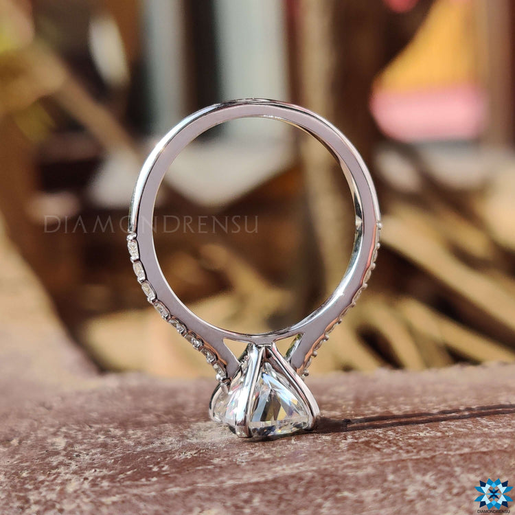 Handmade cushion cut ring with pave accents and cathedral design.
