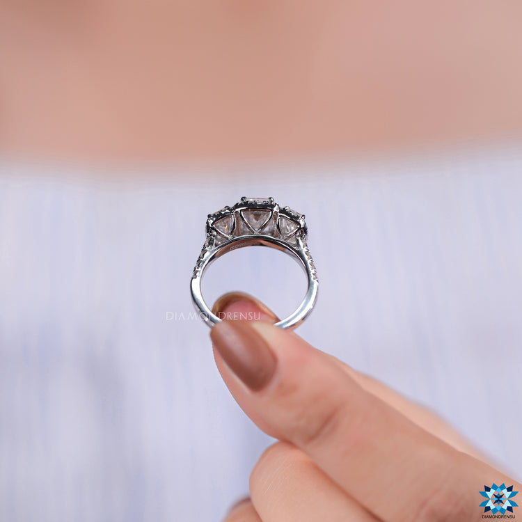 UK engagement ring featuring emerald cut moissanite and cathedral mount.
