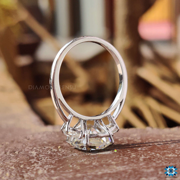 White gold engagement ring with three moissanite stones.

