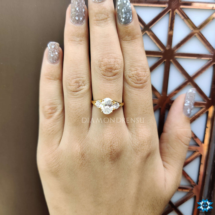 Oval moissanite center stone ring with round side stones.
