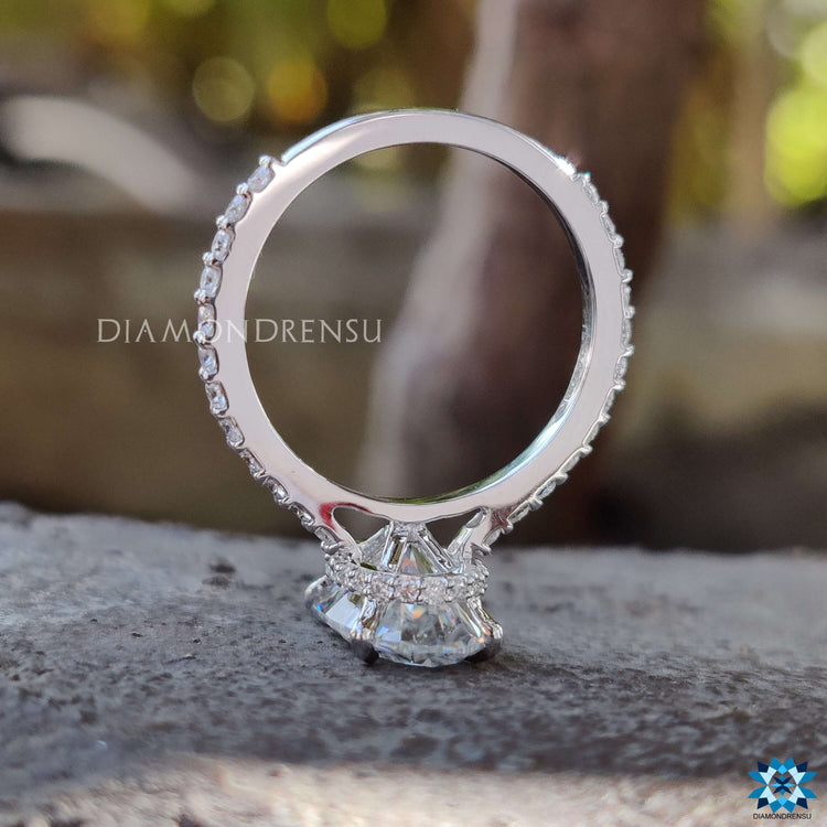 Hidden halo moissanite engagement ring with round side stones.
