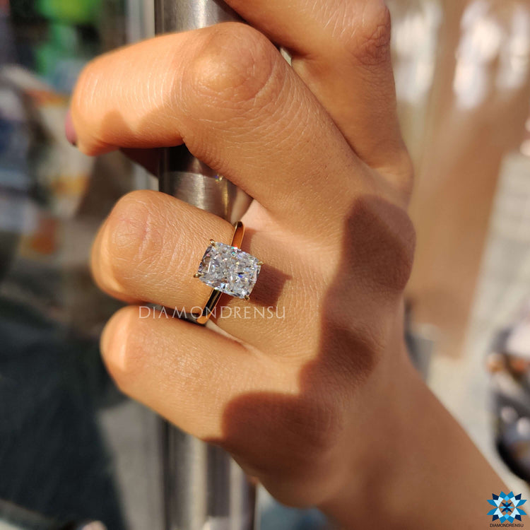 Yellow gold engagement ring featuring a cushion cut moissanite.
