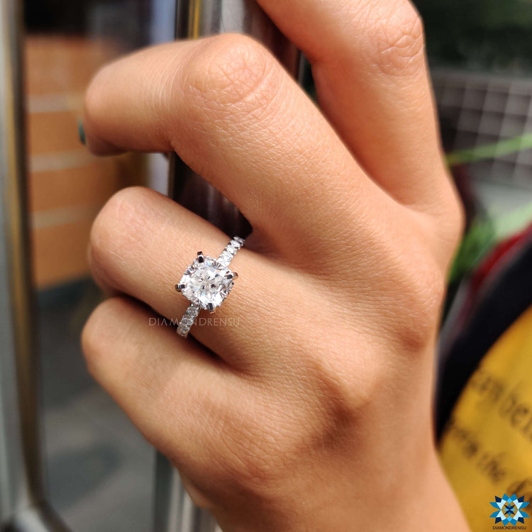 White gold engagement ring with cushion moissanite center.
