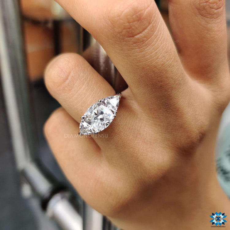 Prong setting ring with cushion moissanite and trillion stones.
