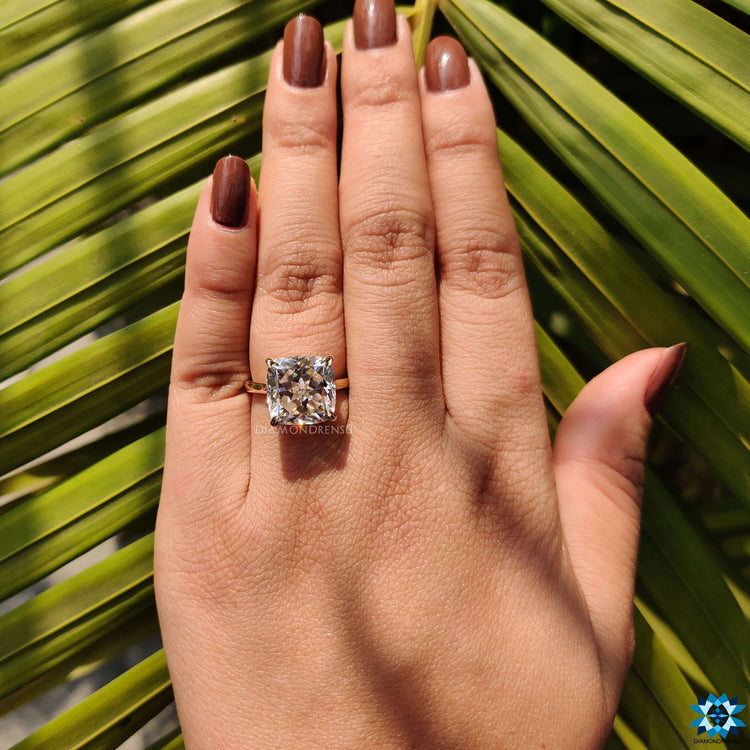 Cushion cut yellow gold ring featuring hidden halo setting.
