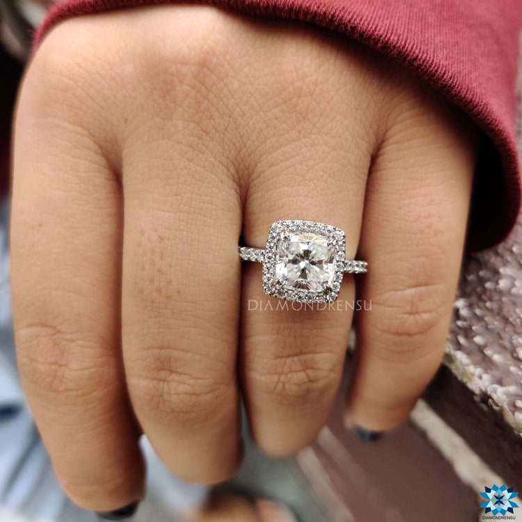 White gold engagement ring with cushion moissanite center.
