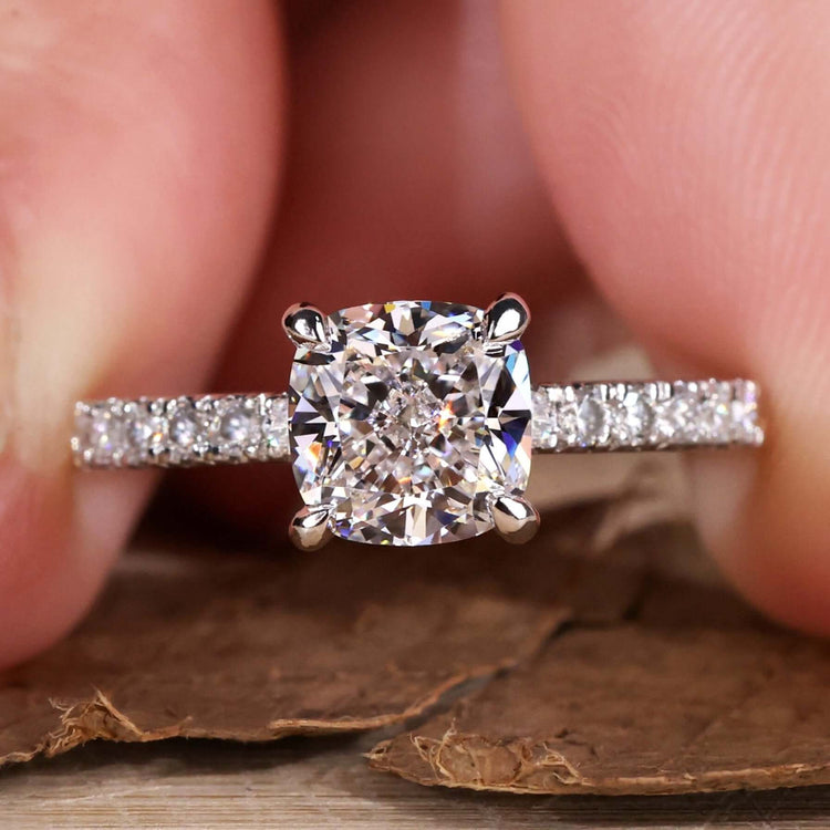 Cushion cut diamond ring in a timeless design with elegant pave setting for a modern yet classic engagement look.
