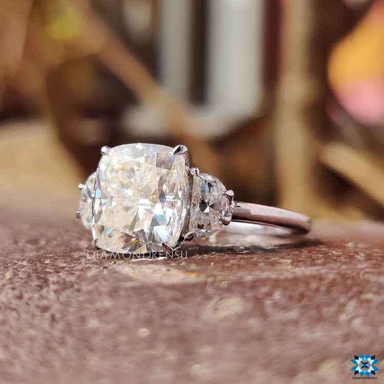 3 stone engagement ring featuring cushion and half moon cuts.
