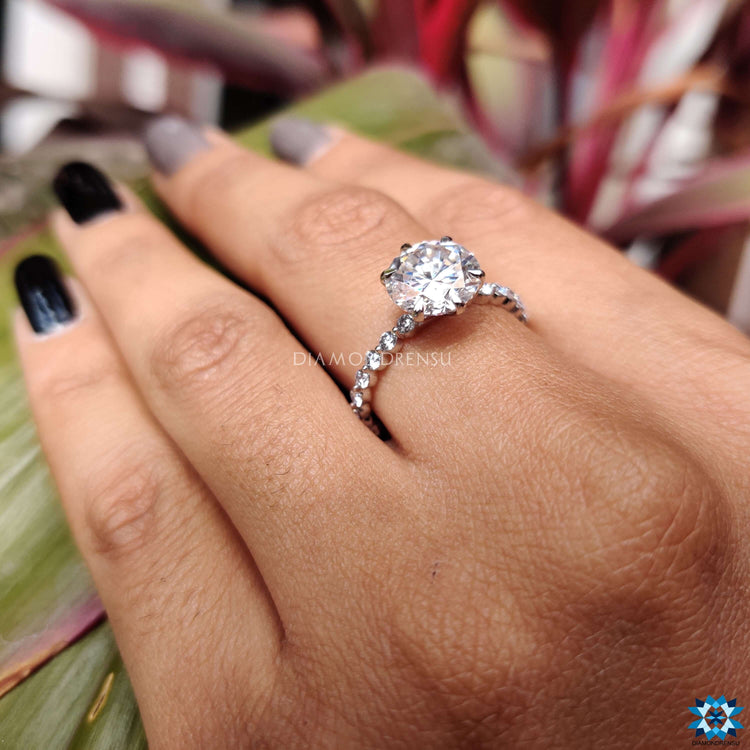 Buy moissanite ring with a 6 prong round cut centre in pave setting.
