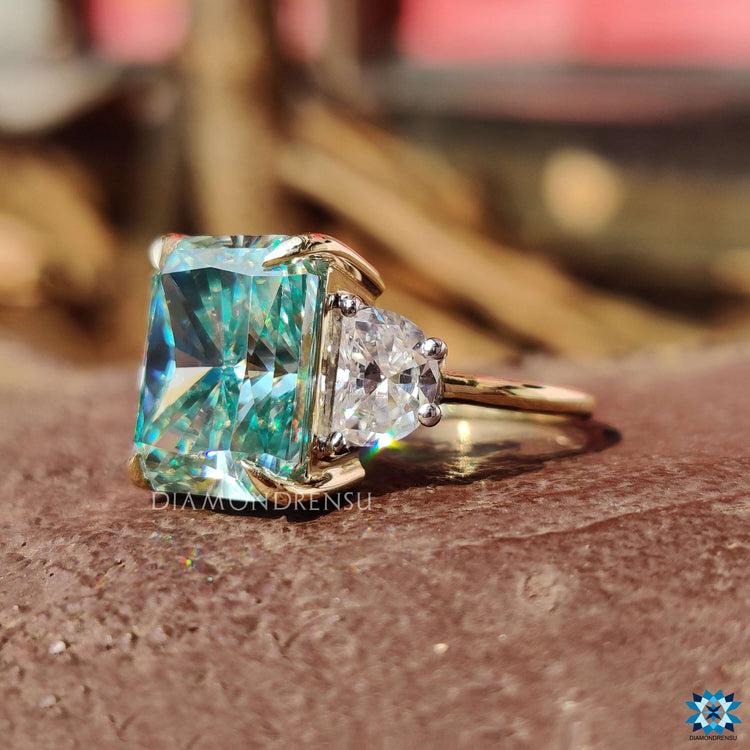 Radiant cut center stone with half moon side stones.
