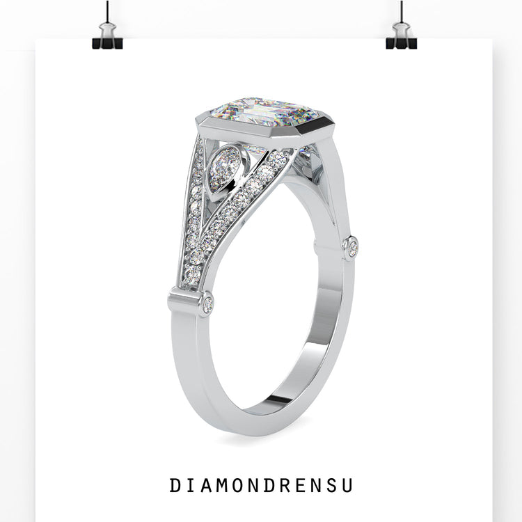 Pear side stone ring with emerald cut diamond in split shank.
