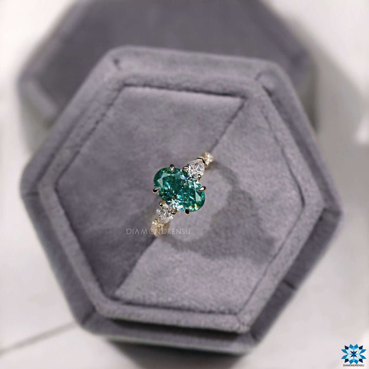 Cyan blue moissanite center stone with pear cut accents on a twisted band.
