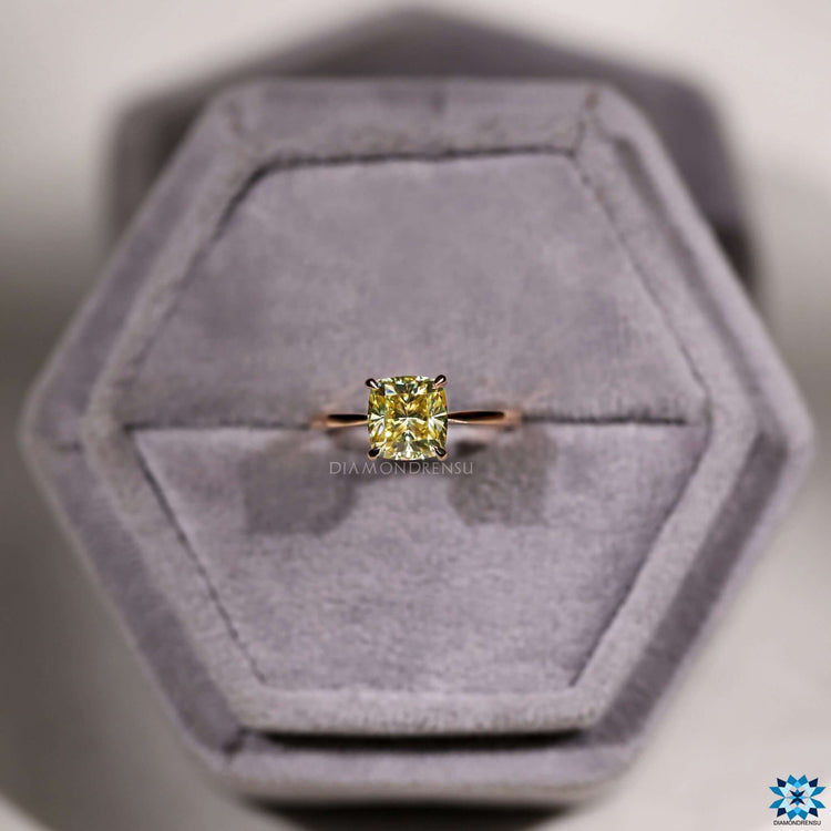 4 prong claw setting holding yellow moissanite.
