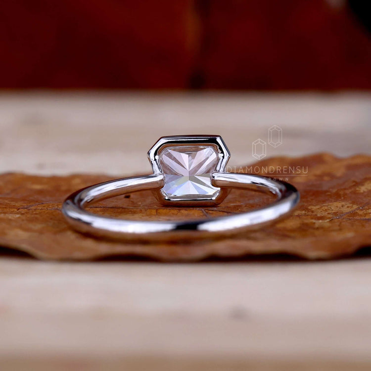 East to West ring featuring a radiant cut diamond in a handmade jewelry design for modern brides.
