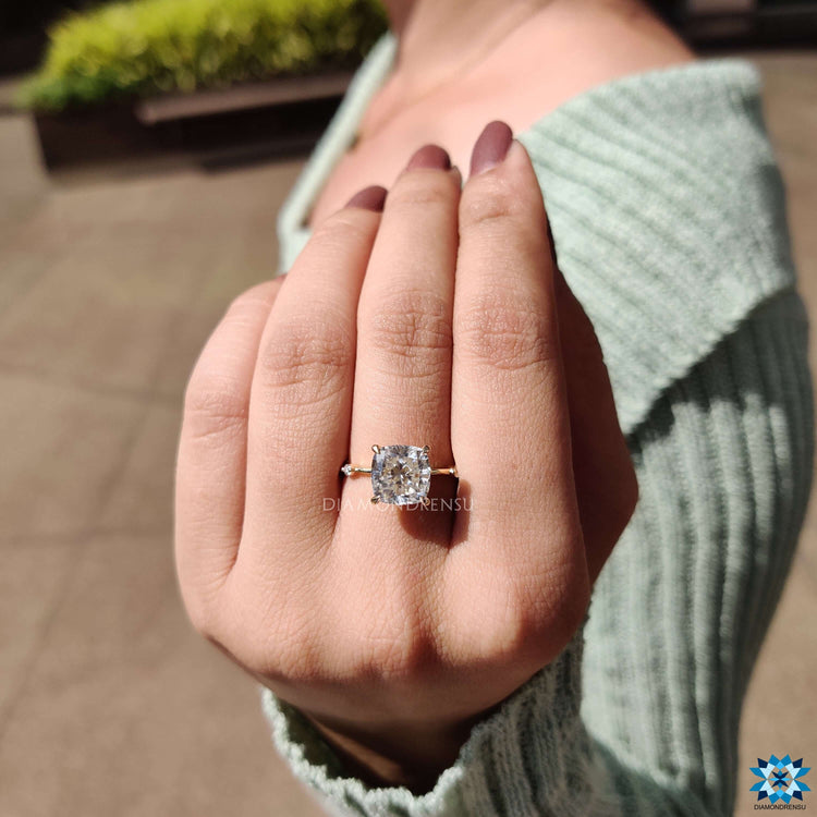 Yellow gold engagement ring with cushion cut center stone.
