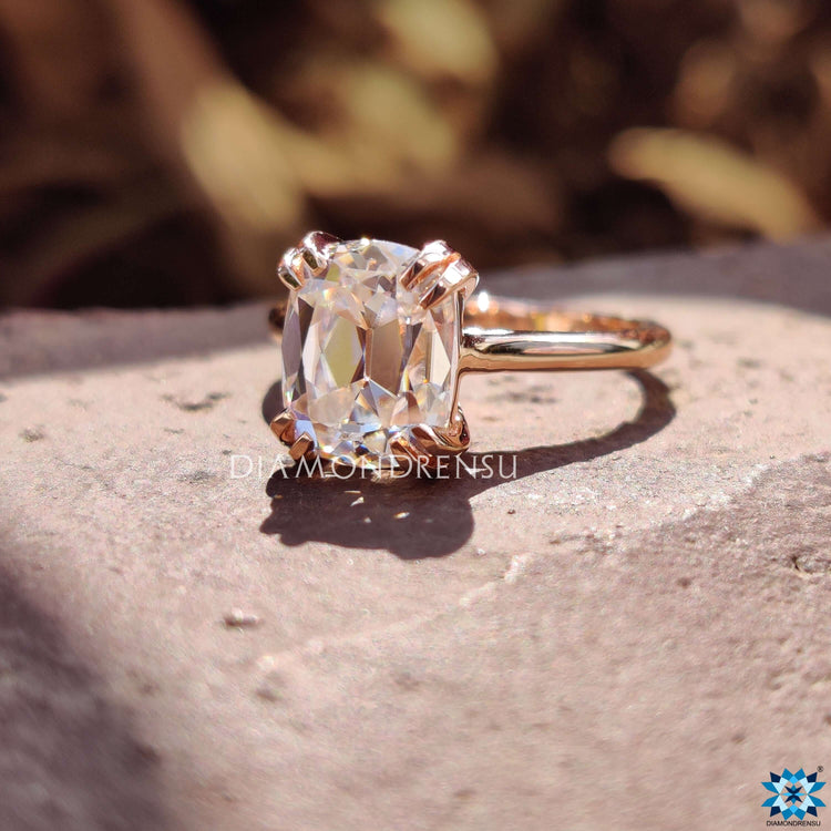 Double prong moissanite engagement ring in rose gold setting.
