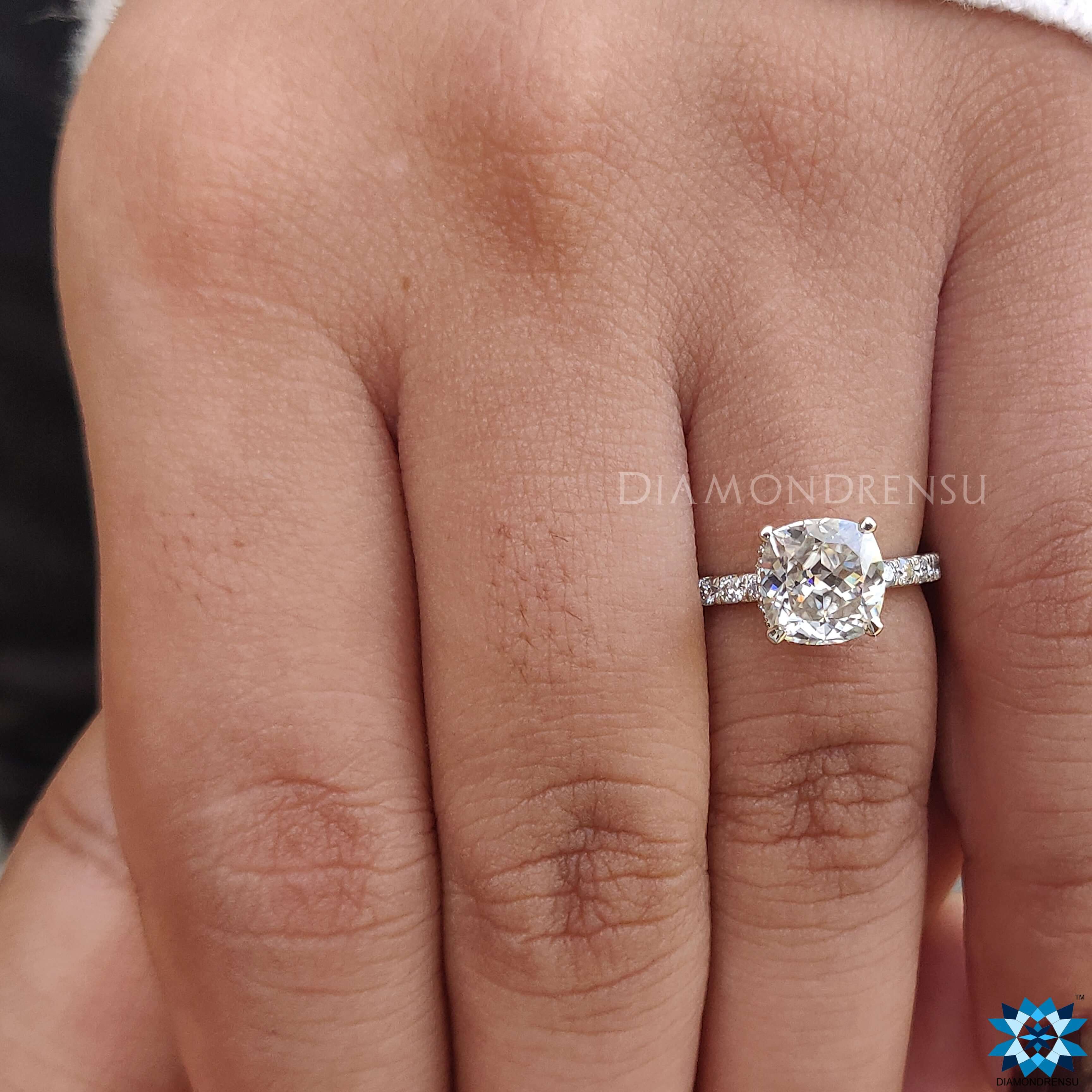 Custom ring featuring a cushion cut moissanite stone with a hidden halo ring design.