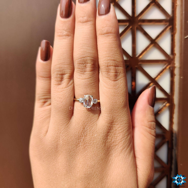 Oval rose cut ring in two-tone gold with round side stones.
