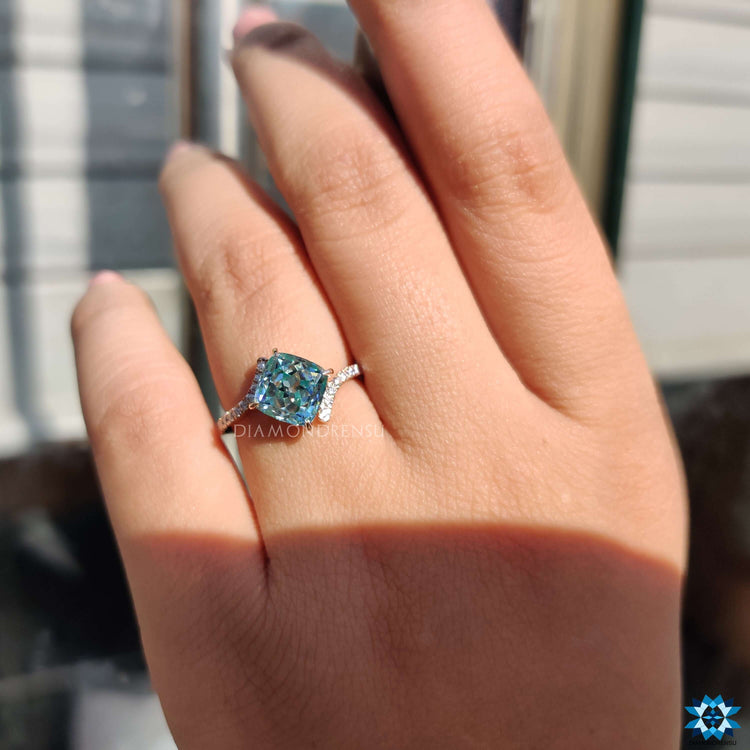 Rose gold engagement ring with bypass design and brilliant blue stone.
