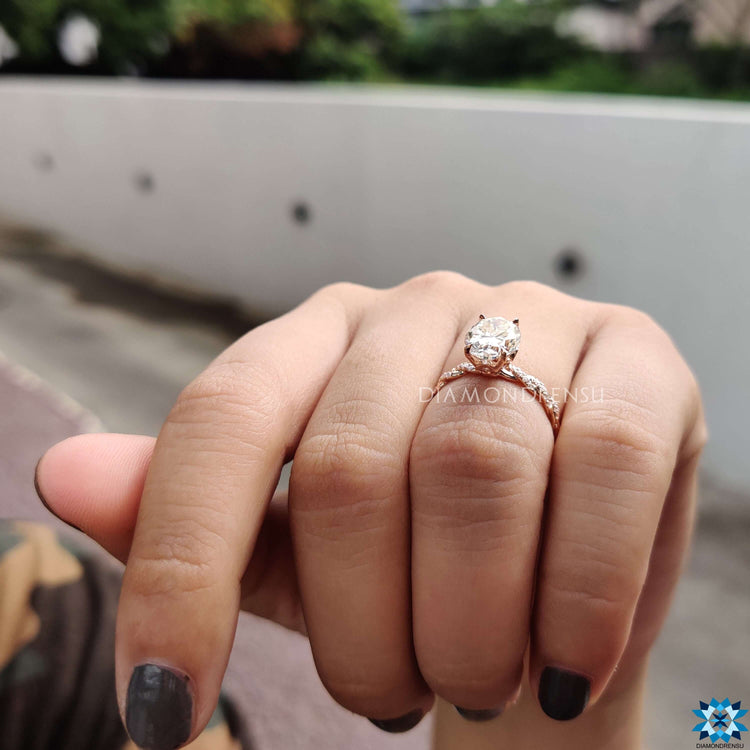 Twisted band ring featuring oval center moissanite and under halo detail.
