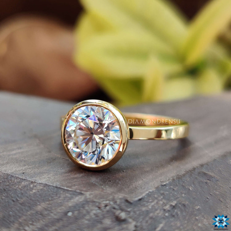 Handmade jewelry with round Moissanite bezel set in classic yellow gold.
