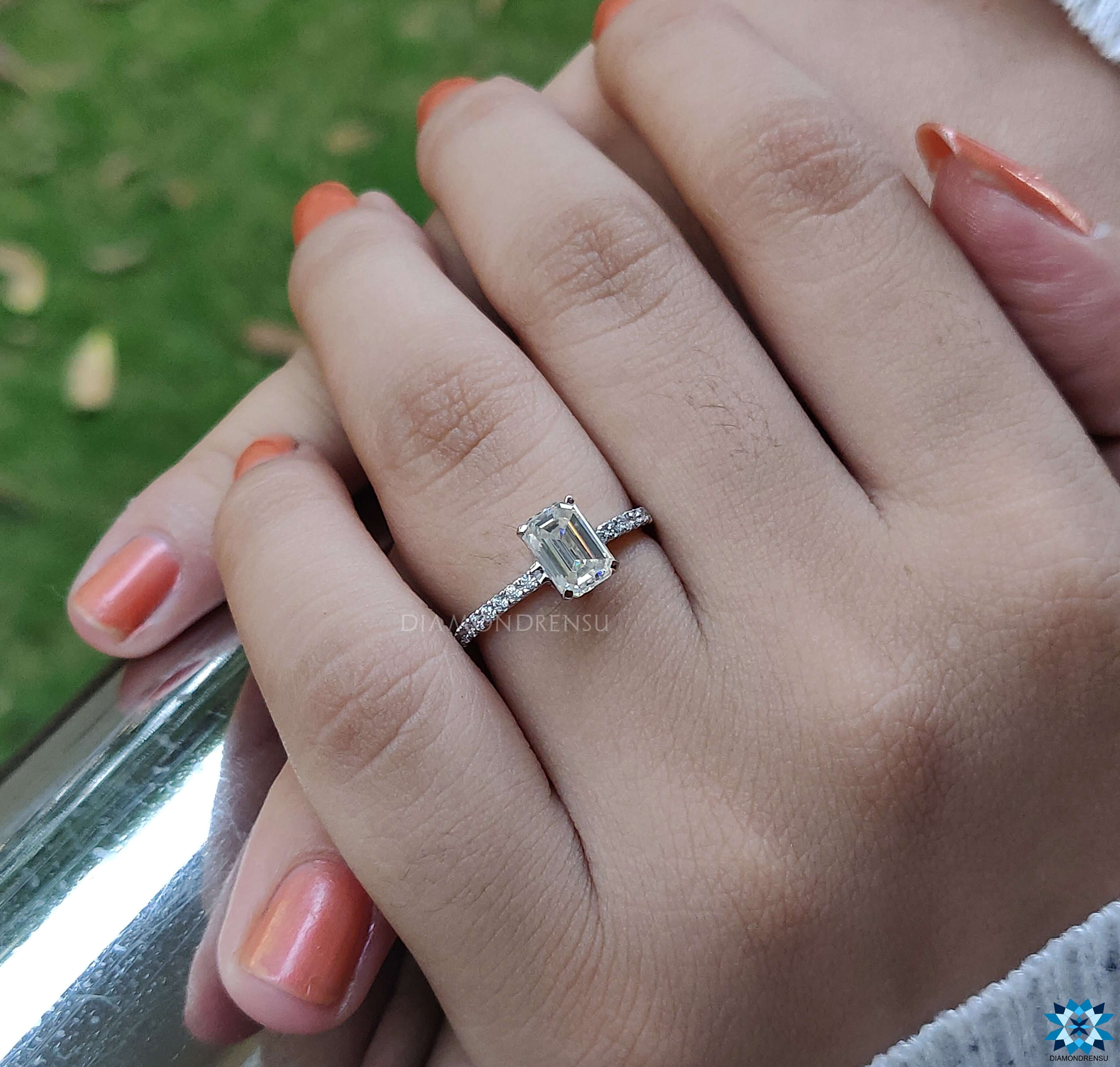 Handmade ring featuring an emerald cut moissanite and pave setting.