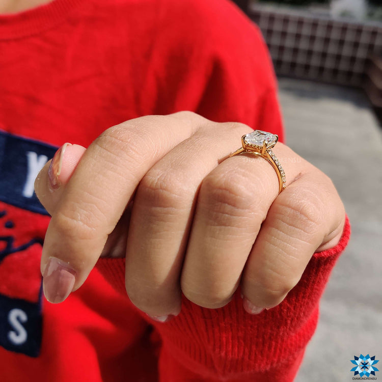 Emerald moissanite ring with handcrafted round cut pave band in gold.

