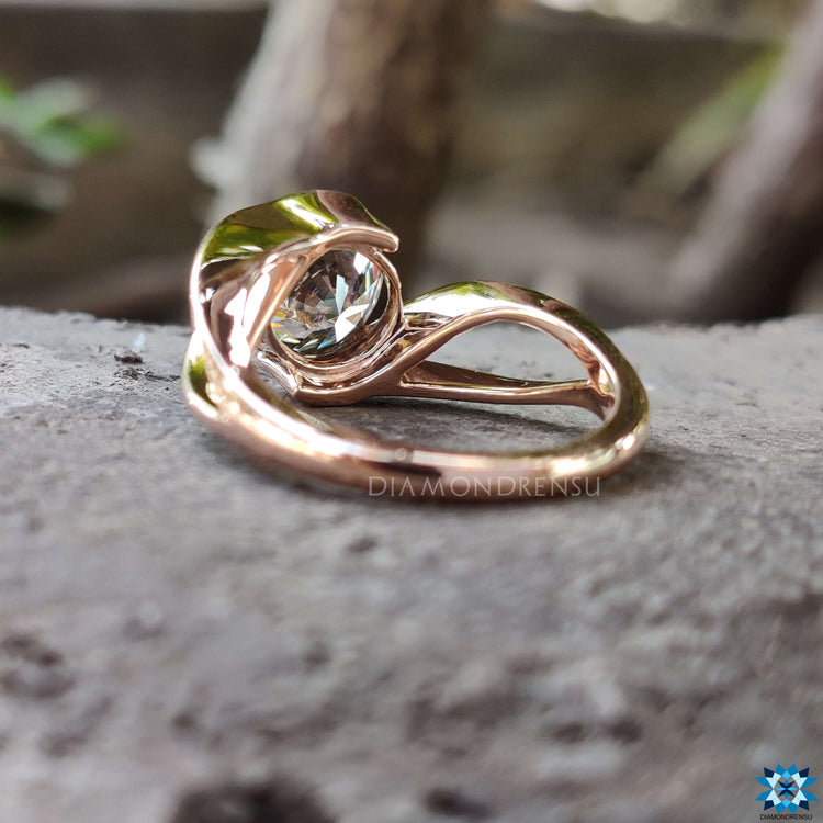 Round cut moissanite ring in minimalist rose gold setting.
