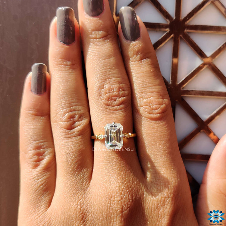 Custom emerald cut moissanite engagement ring in yellow gold.
