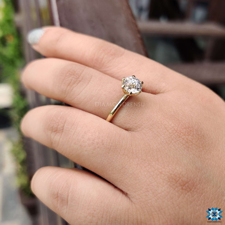 Elegant round cut moissanite ring with floral-inspired prongs.
