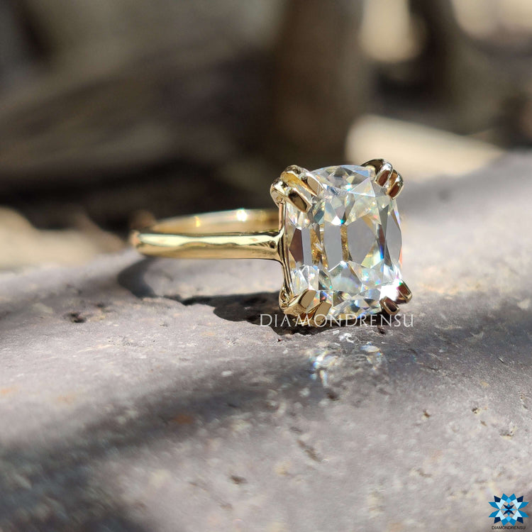 Cathedral setting yellow gold ring with cushion moissanite.
