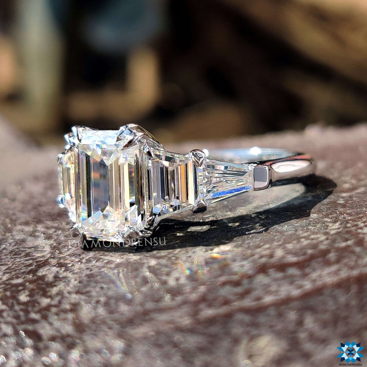 Emerald cut moissanite ring with tapered baguette side stones.

