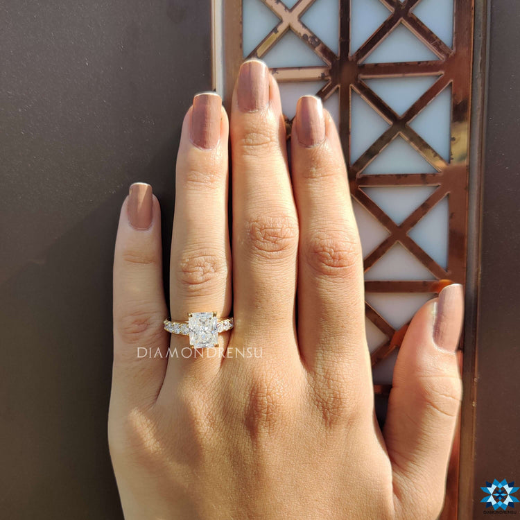 Radiant moissanite center with round cut pave band.

