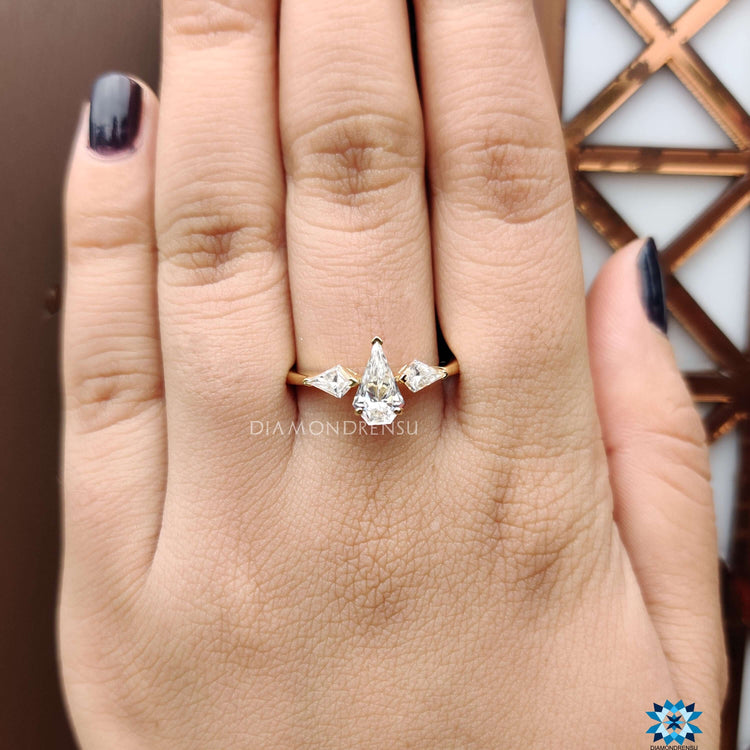 Three stone engagement ring with kite cut side stones.
