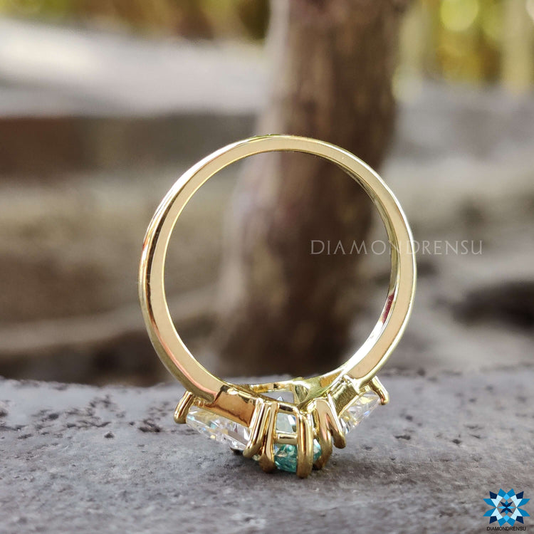 Prong setting engagement ring with cyan blue moissanite stones.
