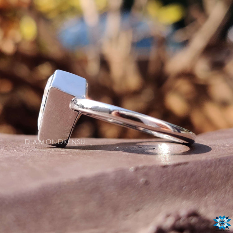 White gold moissanite ring with shield cut center.
