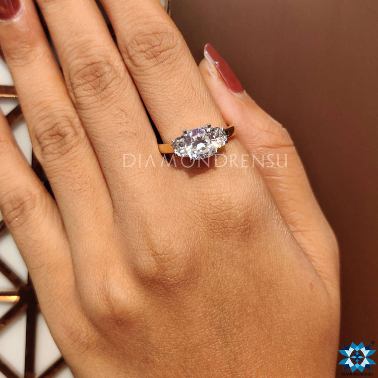 Three stone moissanite ring featuring cushion and half moon cuts.
