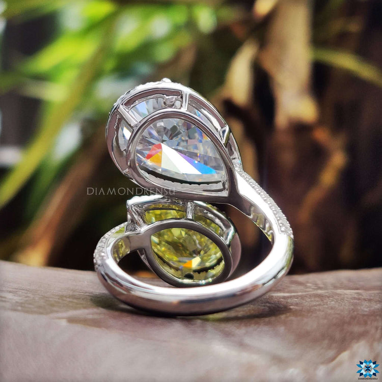 Double pear moissanite ring with three claw prong and pave set band.
