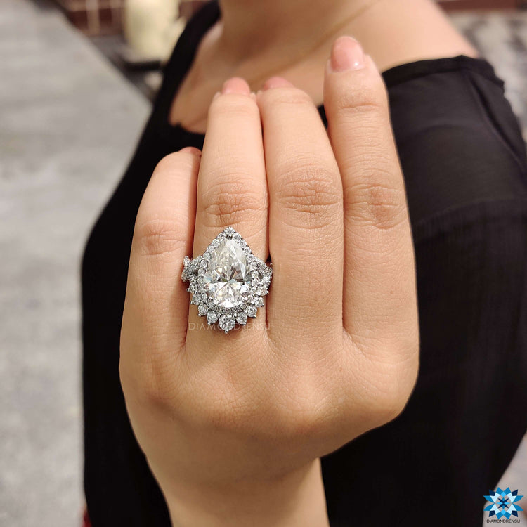 Halo engagement ring featuring pear shaped moissanite.
