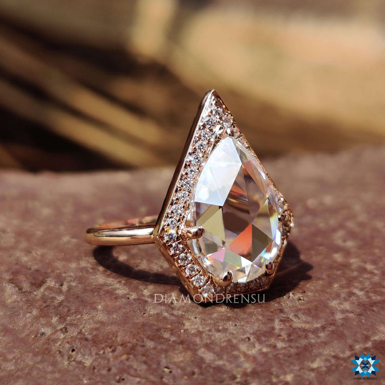 Rose gold pear cut moissanite halo ring.
