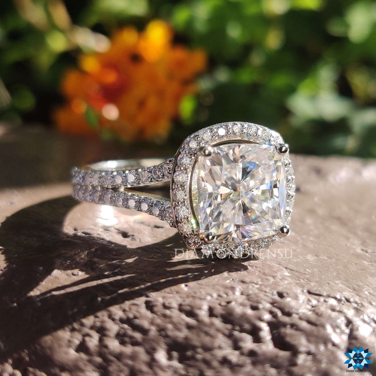 Round and cushion cut moissanite ring with bridge accent.
