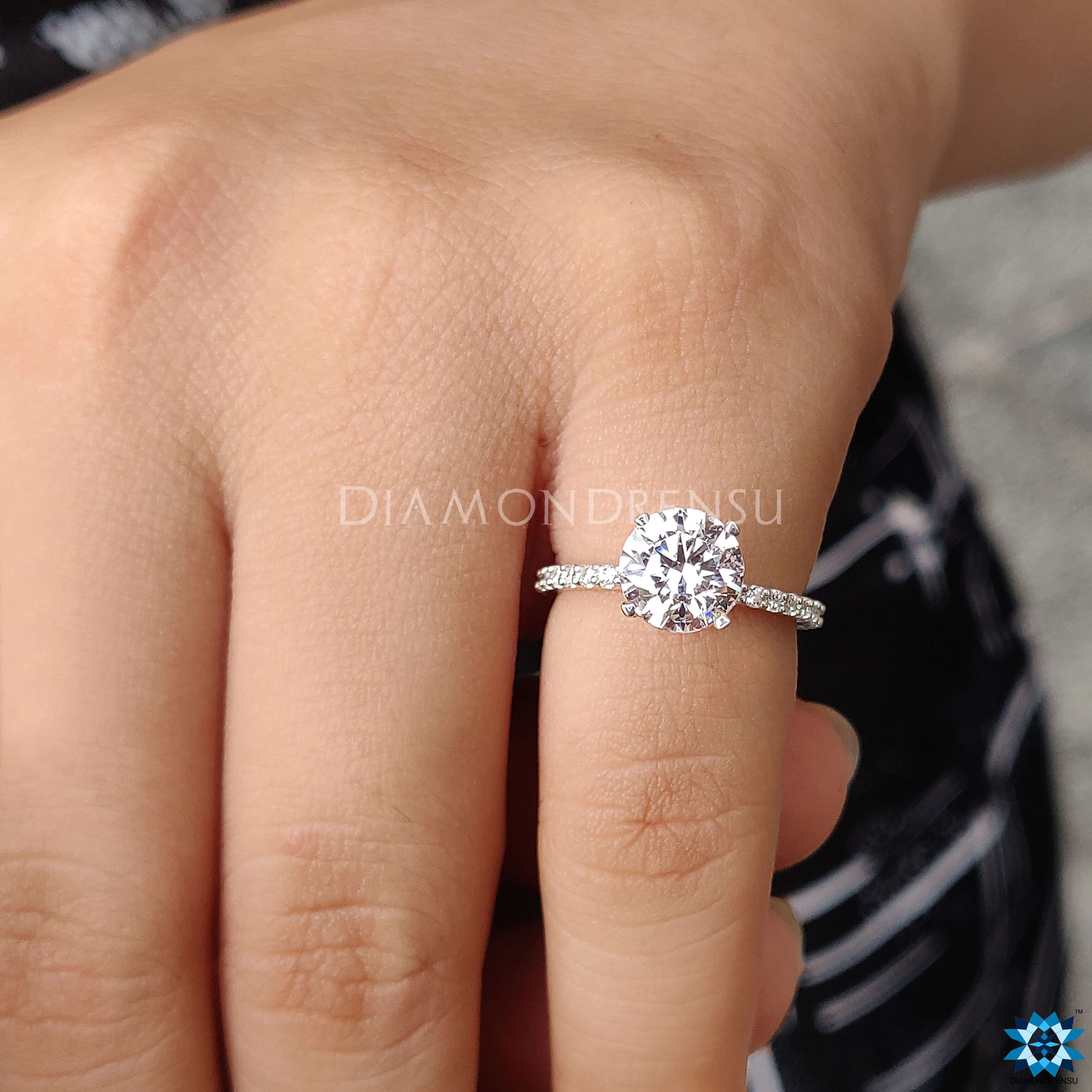 Round cut moissanite ring set in a beautiful hidden halo ring design.